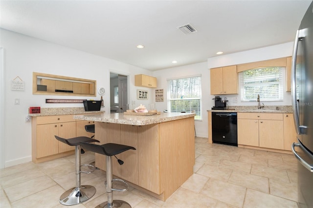 kitchen featuring dishwasher and light brown cabinets