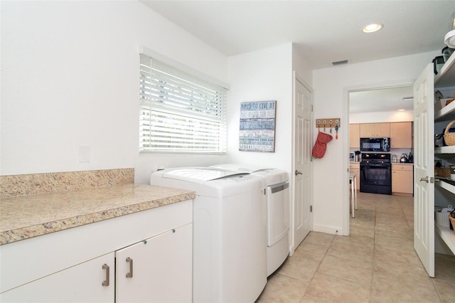 laundry room featuring light tile patterned flooring, cabinets, and separate washer and dryer