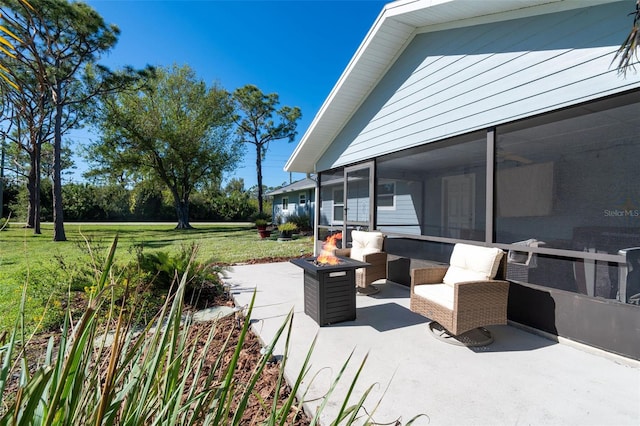 view of patio / terrace featuring an outdoor fire pit and a sunroom