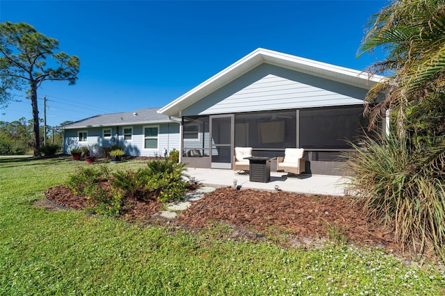 back of house with a sunroom, a patio area, and a lawn