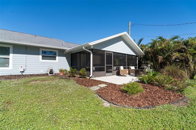 rear view of property with a sunroom, a yard, and a patio