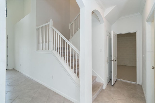 staircase with tile patterned flooring and ornamental molding