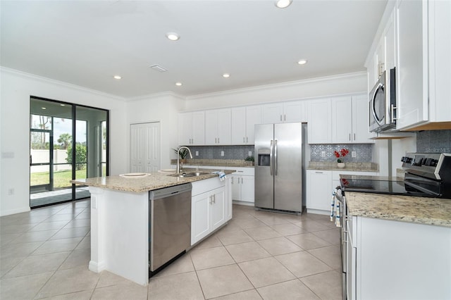 kitchen featuring crown molding, appliances with stainless steel finishes, decorative backsplash, an island with sink, and white cabinets