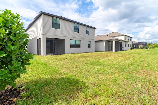 back of property featuring a sunroom and a lawn