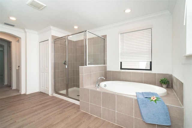 bathroom with independent shower and bath, wood-type flooring, and crown molding