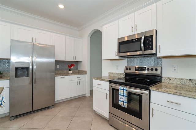 kitchen featuring crown molding, white cabinets, light tile patterned floors, and stainless steel appliances