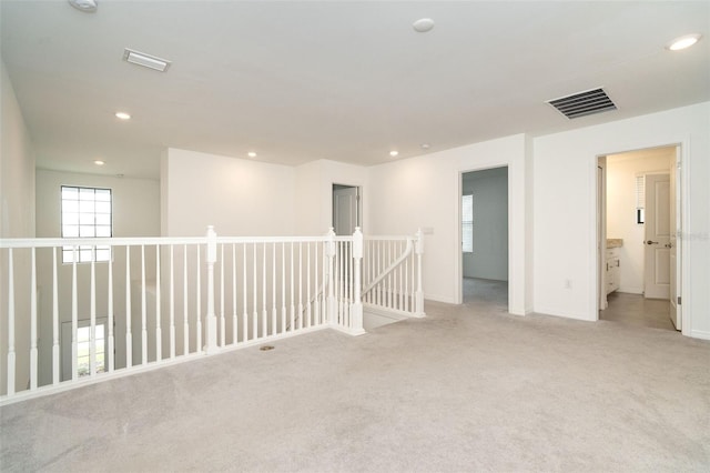 spare room with recessed lighting, visible vents, and light carpet