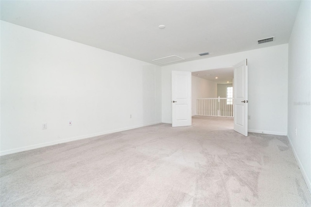 unfurnished room with light colored carpet, baseboards, and visible vents