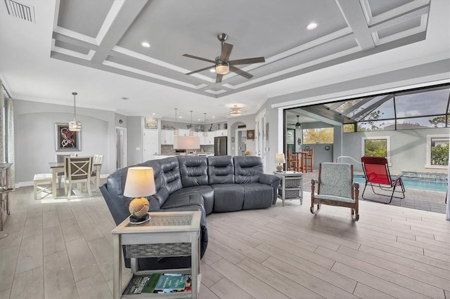 living room with light wood-type flooring, coffered ceiling, ceiling fan, and crown molding