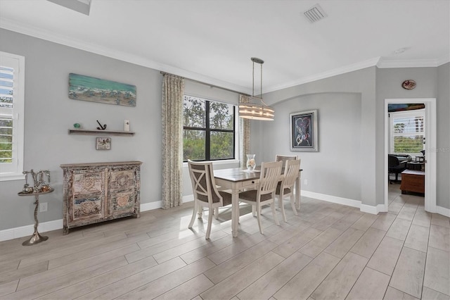 dining area with light hardwood / wood-style flooring and crown molding