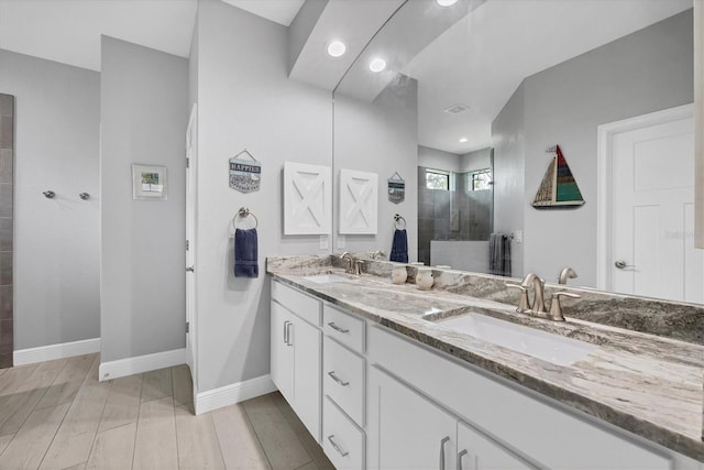 bathroom featuring hardwood / wood-style floors, walk in shower, and vanity