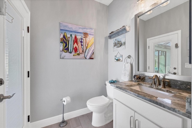 bathroom with hardwood / wood-style floors, vanity, and toilet