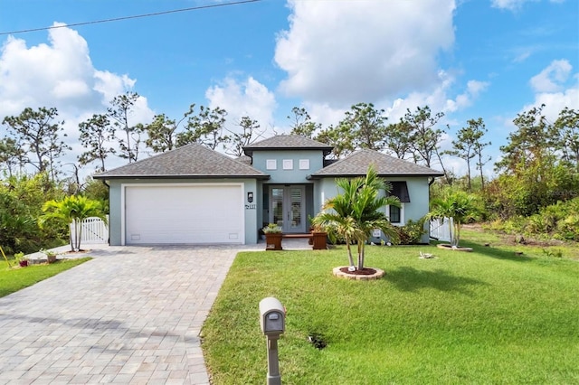 view of front of house featuring a front yard, french doors, and a garage