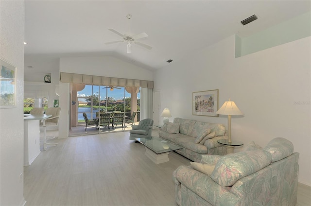 living room featuring a water view, light hardwood / wood-style flooring, ceiling fan, and lofted ceiling