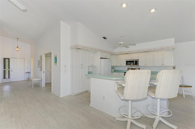 kitchen with ceiling fan, white refrigerator, decorative light fixtures, high vaulted ceiling, and light hardwood / wood-style flooring