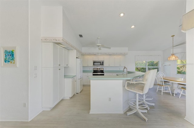 kitchen with appliances with stainless steel finishes, ceiling fan, light hardwood / wood-style flooring, white cabinetry, and lofted ceiling