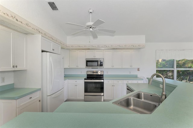 kitchen featuring lofted ceiling, white cabinets, sink, ceiling fan, and appliances with stainless steel finishes