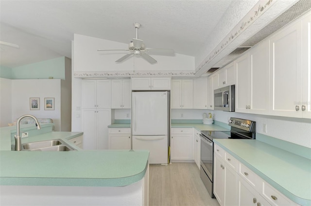 kitchen with white cabinets, lofted ceiling, sink, and appliances with stainless steel finishes