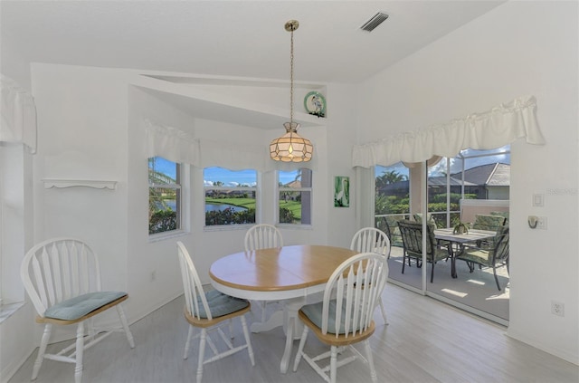 dining space featuring lofted ceiling and light hardwood / wood-style flooring