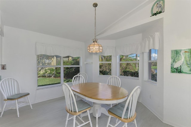 dining space featuring lofted ceiling and light wood-type flooring