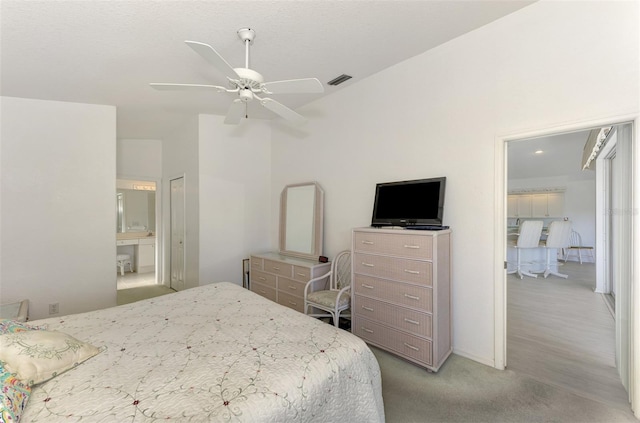 bedroom featuring ensuite bath, light carpet, and ceiling fan