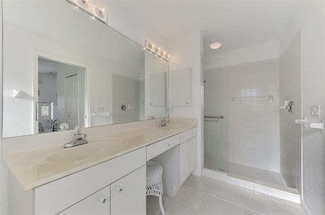 bathroom with tile patterned floors, vanity, and a tile shower