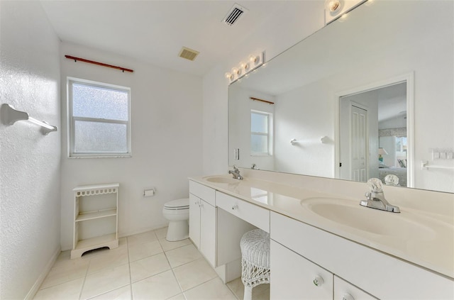 bathroom featuring tile patterned flooring, vanity, toilet, and a healthy amount of sunlight