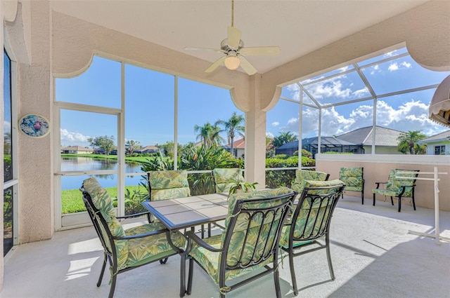 sunroom / solarium featuring ceiling fan and a water view