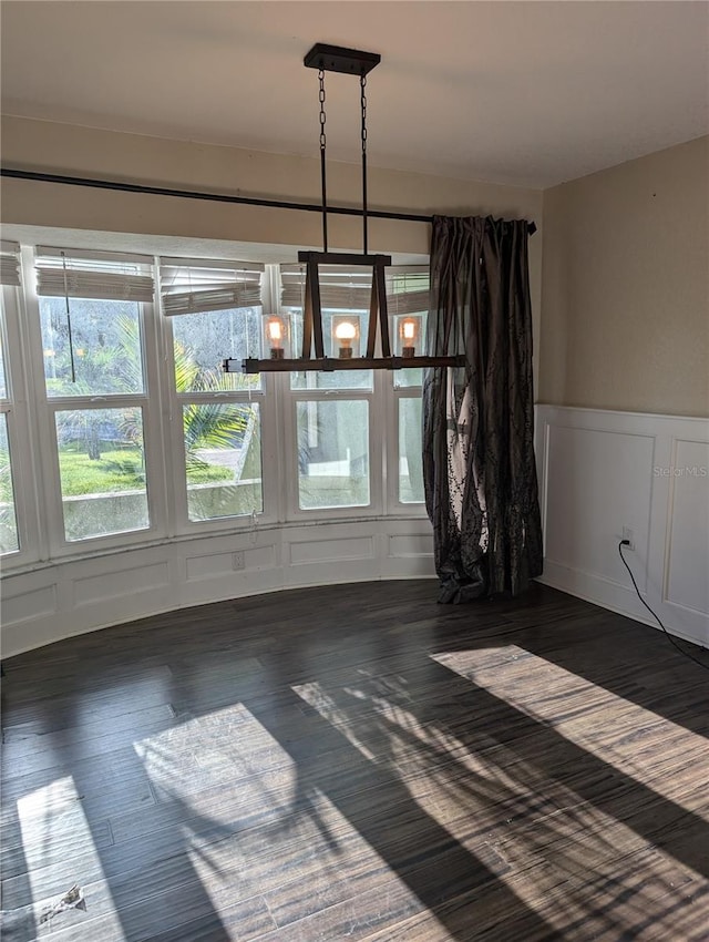 unfurnished dining area with dark wood-type flooring