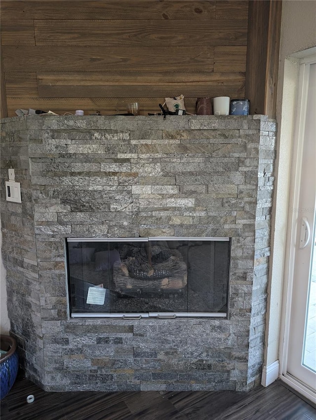 interior details with hardwood / wood-style floors and a stone fireplace