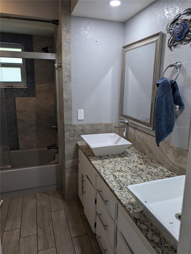 bathroom with vanity and shower / bath combination with glass door