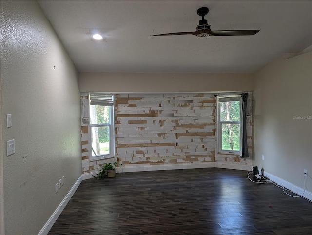 unfurnished room with ceiling fan, a healthy amount of sunlight, and dark hardwood / wood-style flooring