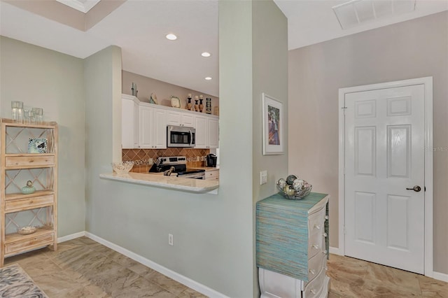 kitchen with tasteful backsplash, white cabinetry, and appliances with stainless steel finishes