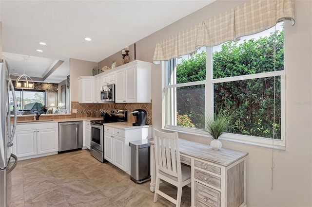 kitchen featuring white cabinetry, stainless steel appliances, sink, and backsplash