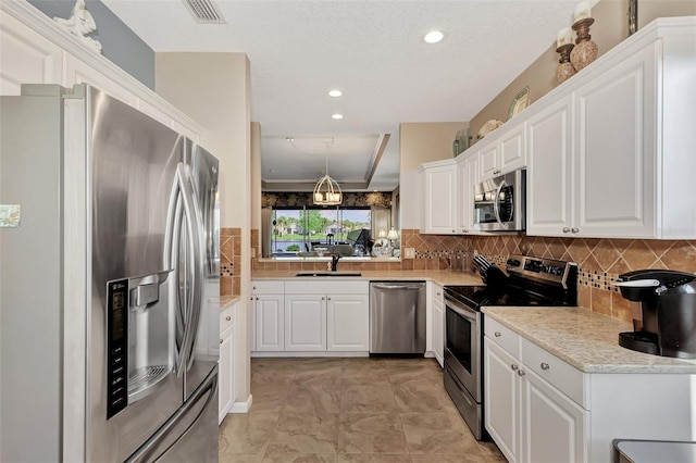 kitchen with white cabinets, appliances with stainless steel finishes, sink, and backsplash