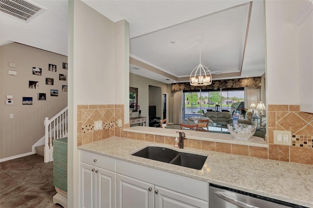 kitchen with dishwasher, sink, a chandelier, backsplash, and white cabinetry