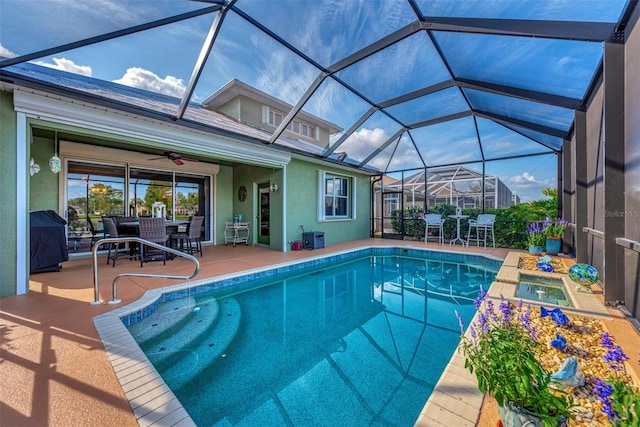 view of swimming pool with ceiling fan, a lanai, a grill, and a patio area