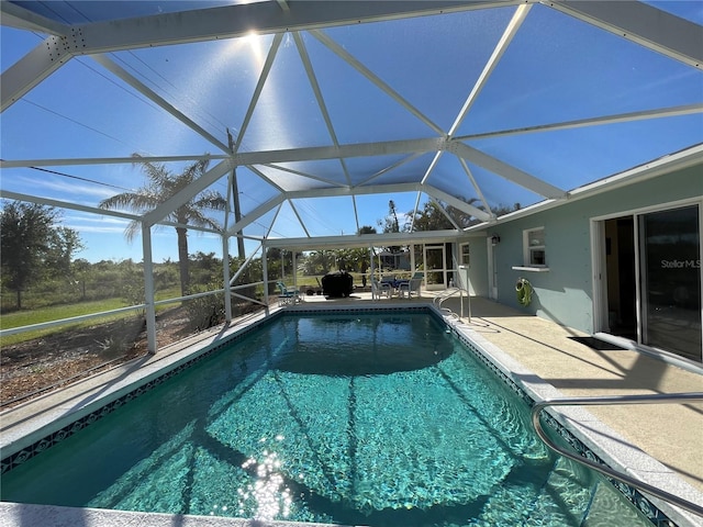 view of swimming pool with glass enclosure and a patio area