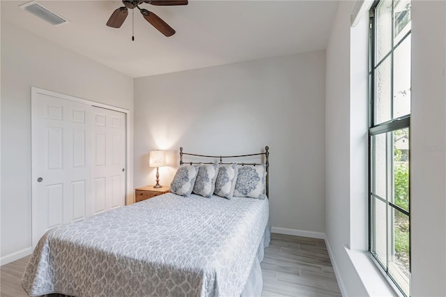 bedroom with ceiling fan, a closet, and light hardwood / wood-style flooring