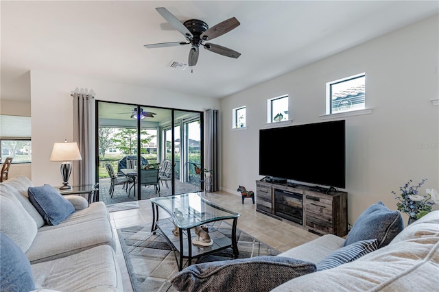 tiled living room featuring ceiling fan and a healthy amount of sunlight