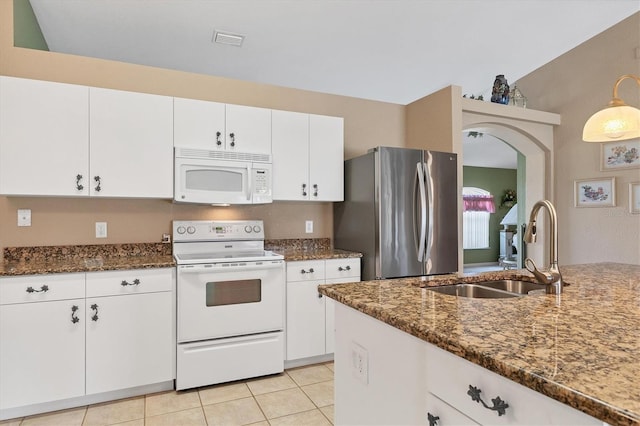 kitchen with white cabinets, sink, white appliances, and dark stone countertops