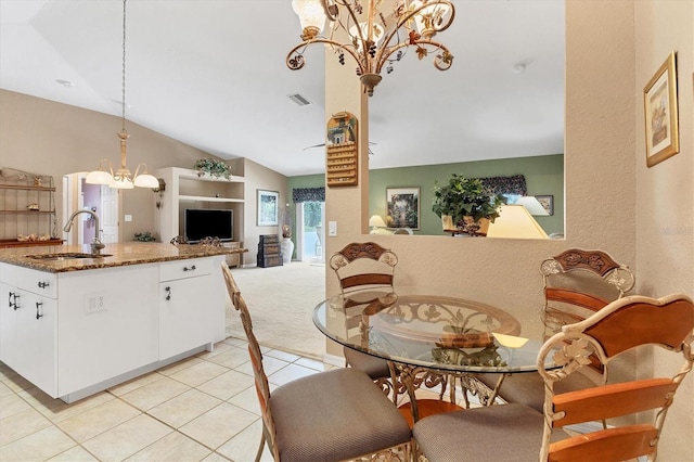 tiled dining space featuring sink, lofted ceiling, and a notable chandelier