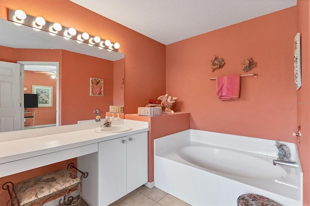 bathroom with tile patterned flooring, a textured ceiling, a bathtub, vanity, and ceiling fan