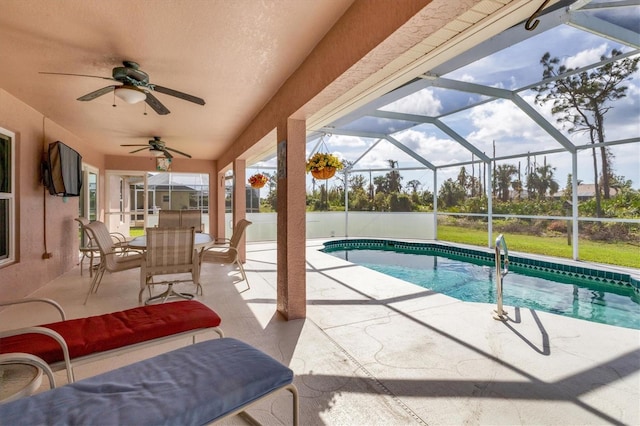 view of pool featuring glass enclosure, ceiling fan, and a patio area