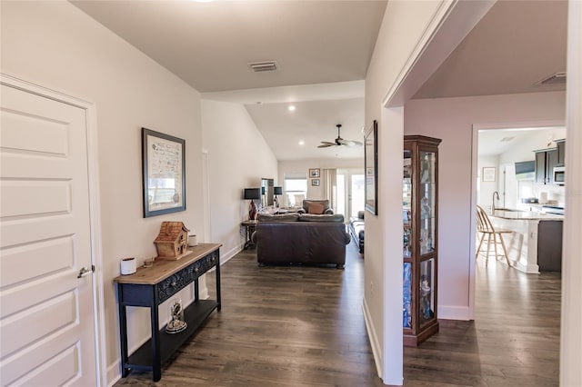 corridor with dark hardwood / wood-style flooring and lofted ceiling