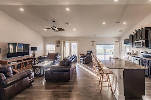 living room with plenty of natural light, sink, and vaulted ceiling