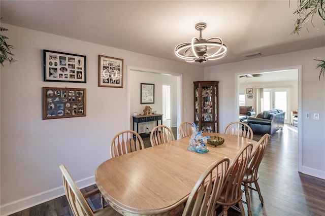 dining area featuring dark hardwood / wood-style flooring and an inviting chandelier