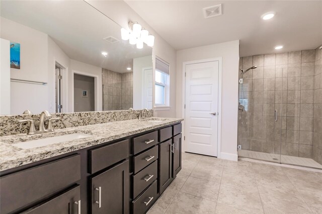 bathroom featuring tile patterned flooring, an enclosed shower, and vanity