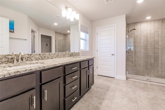 bathroom with tile patterned flooring, vanity, and a shower with door