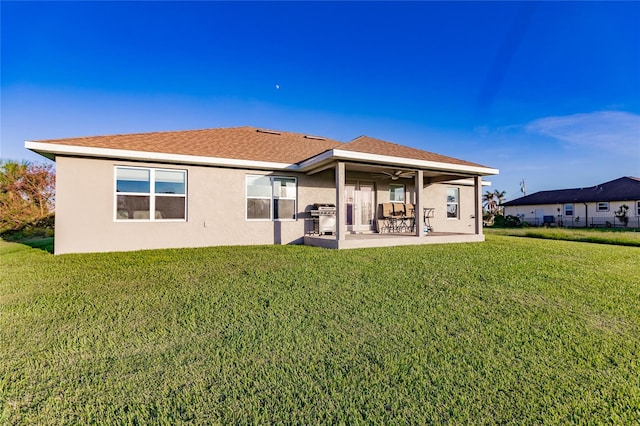 back of property featuring a patio, a lawn, and ceiling fan